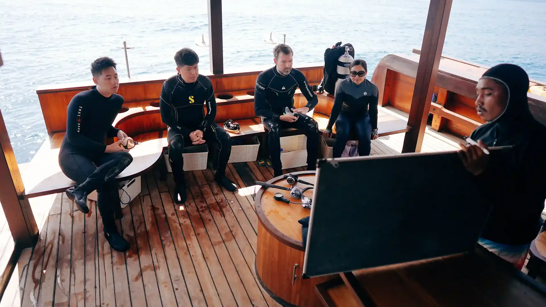 Divers listening to a dive briefing on a boat deck